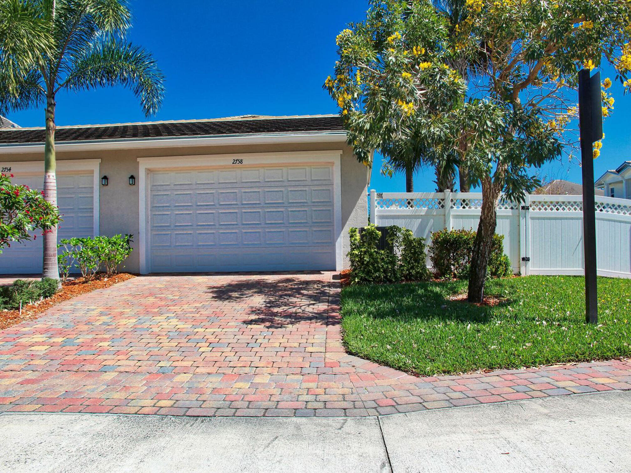 2758 Avalon Way Jupiter, FL 33458 - Photo 4 of 51 a front view of a house with a garden