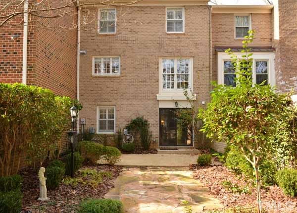 3002 Wycliff Road Raleigh, NC 27607 - Photo 15 of 21 a view of a brick house with many windows next to a yard