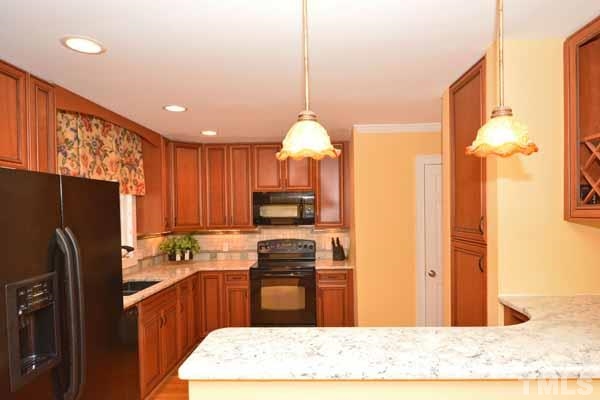 3002 Wycliff Road Raleigh, NC 27607 - Photo 9 of 21 a kitchen with a refrigerator a stove top oven a sink and cabinets
