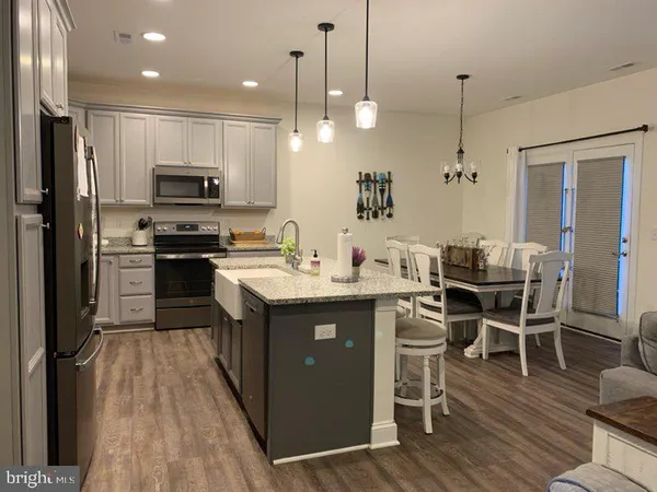 a kitchen with kitchen island granite countertop a sink appliances and cabinets