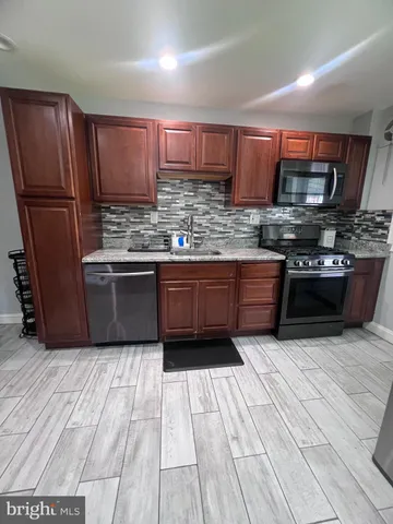 a kitchen with stainless steel appliances granite countertop a stove a sink dishwasher a refrigerator and a oven