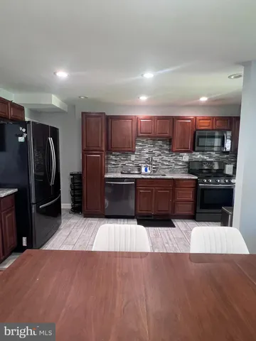 a large kitchen with stainless steel appliances and a refrigerator