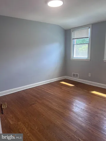 a view of a room with wooden floor and window