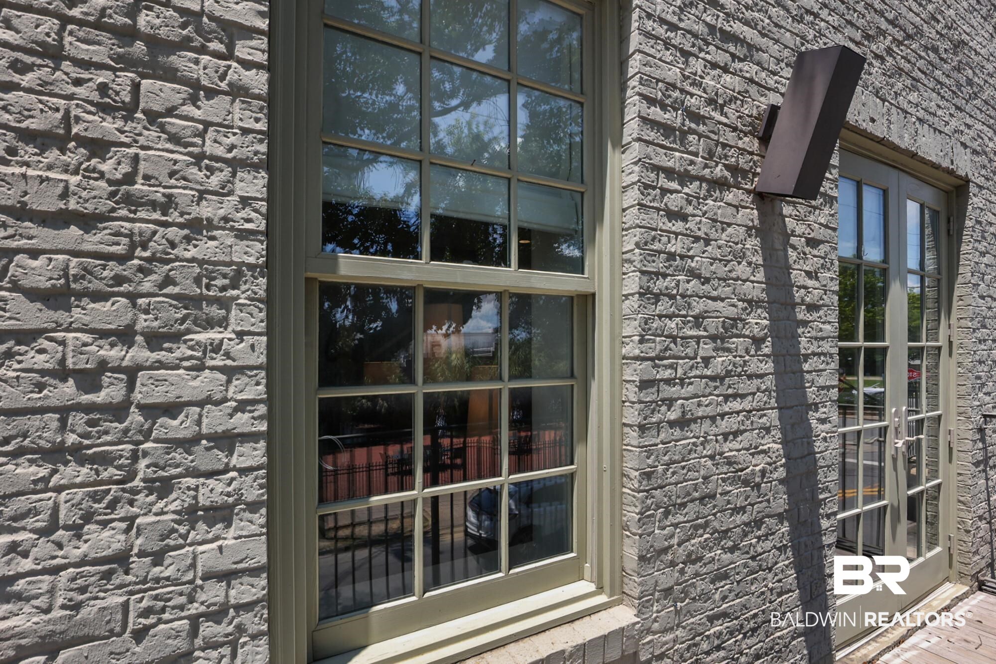 701 Dauphin Street, Unit A Mobile, AL 36602 - Photo 26 of 31 Textured gray brick exterior featuring a large multi-pane window with light-colored trim