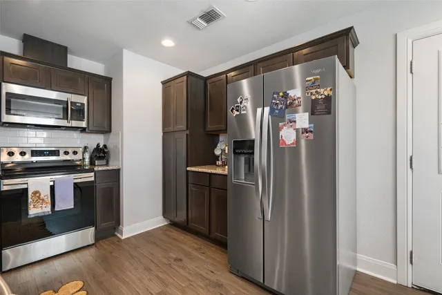 a kitchen with stainless steel appliances granite countertop a sink and stove top oven