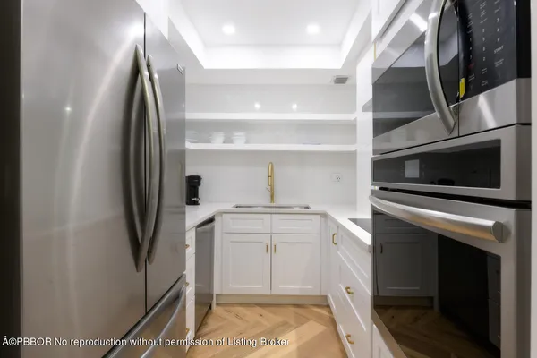 a kitchen with white cabinets and stainless steel appliances