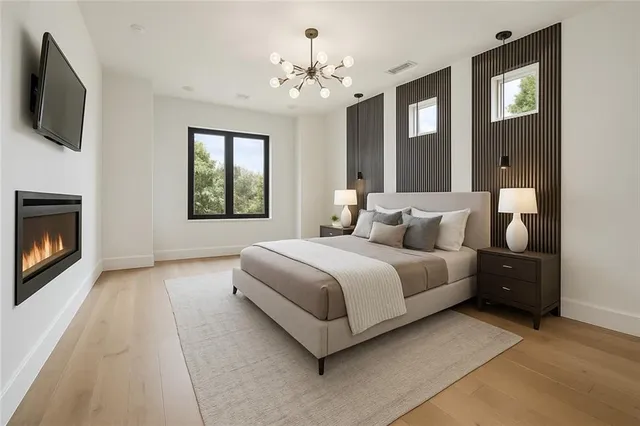 a spacious bedroom with a bed and a flat screen tv