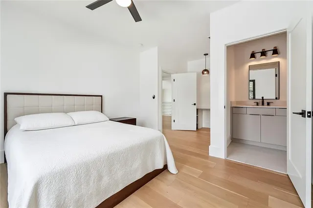 a bedroom with a bed and painting on the wall