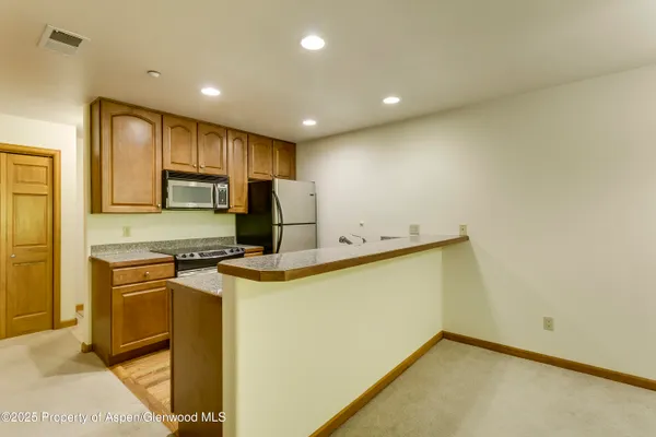 a view of a kitchen with a sink and a refrigerator