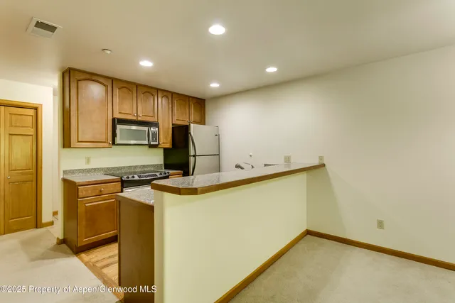 a view of a kitchen with a sink and a refrigerator