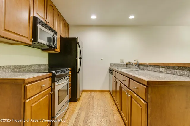 a kitchen with granite countertop cabinets stainless steel appliances and a counter space