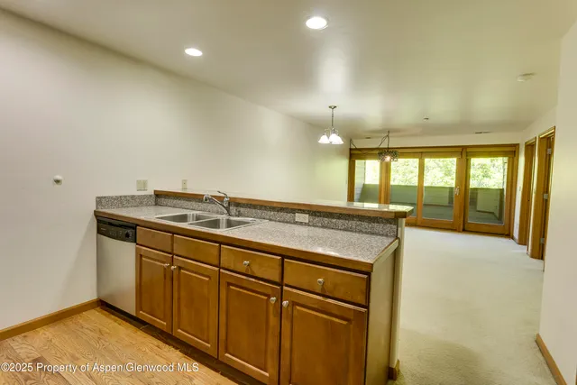 a view of a kitchen with a sink and wooden floor