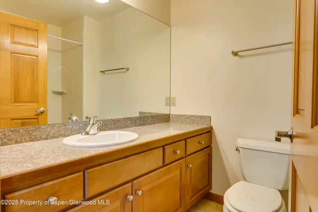 a bathroom with a granite countertop sink toilet and shower