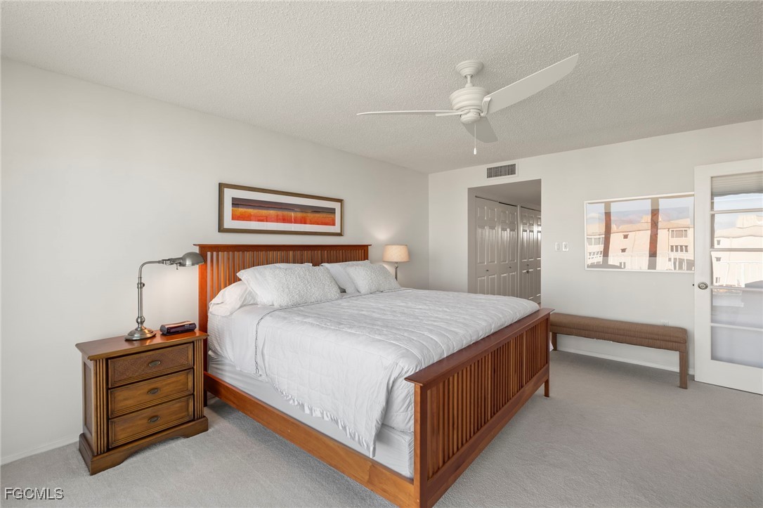 200 Periwinkle Way, Unit 315 Sanibel, FL 33957 - Photo 19 of 33 a bedroom with a bed and a chandelier