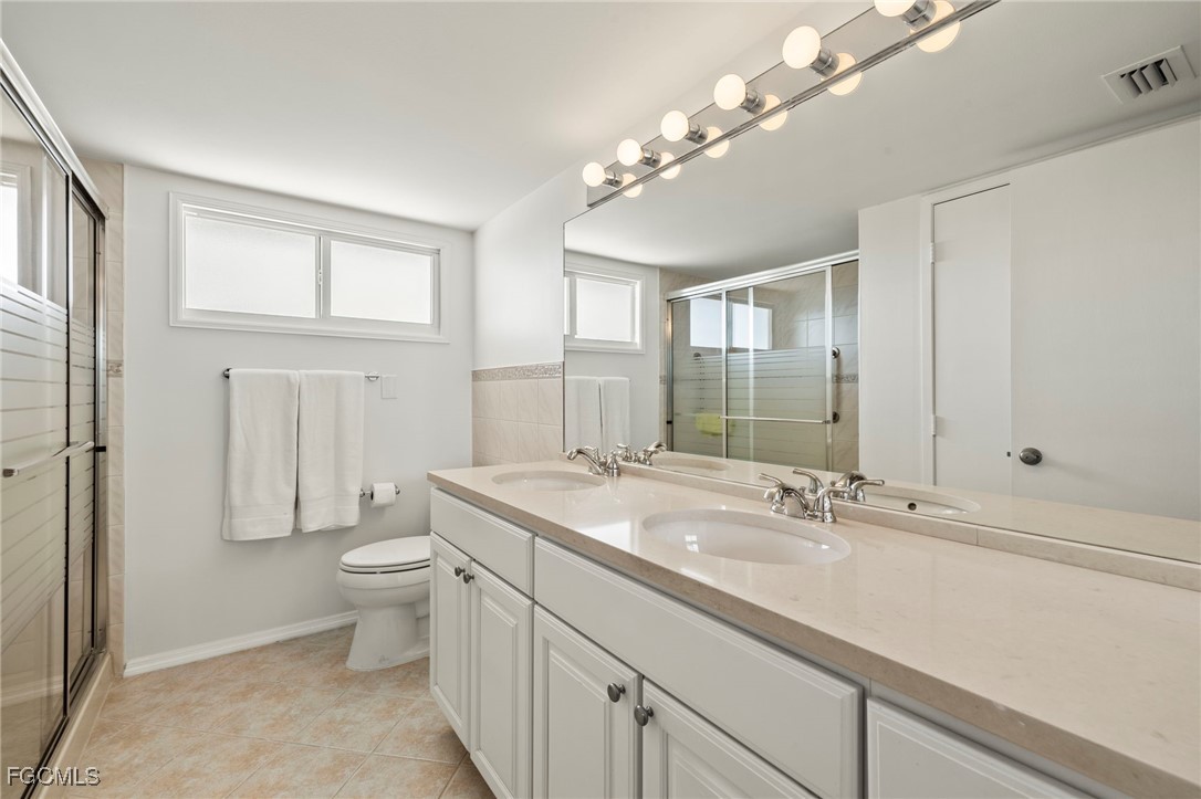 200 Periwinkle Way, Unit 315 Sanibel, FL 33957 - Photo 20 of 33 a bathroom with a toilet a sink and mirror