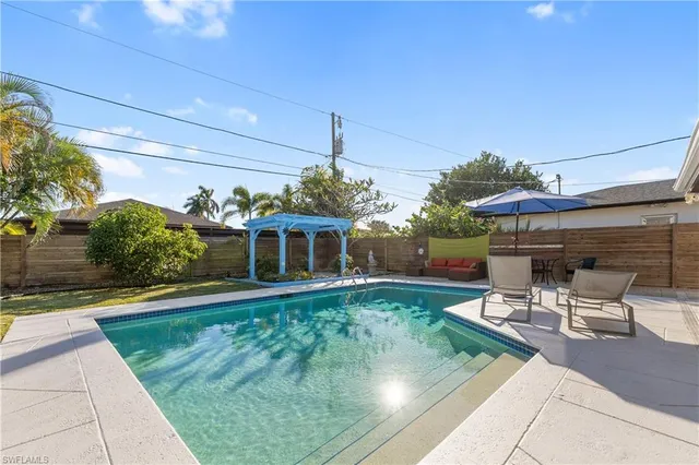 a view of a patio with table and chairs potted plants and floor to ceiling window and potted plants