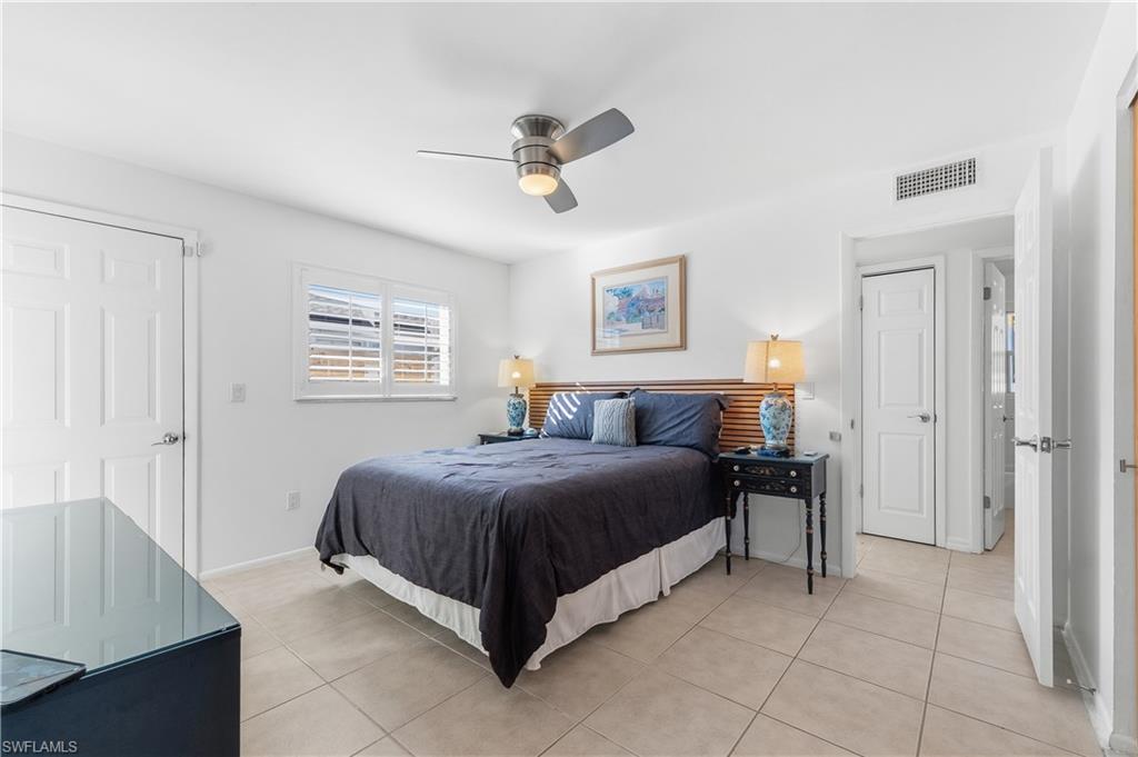 604 110th Avenue North Naples, FL 34108 - Photo 15 of 41 a spacious bedroom with a bed and a cabinets