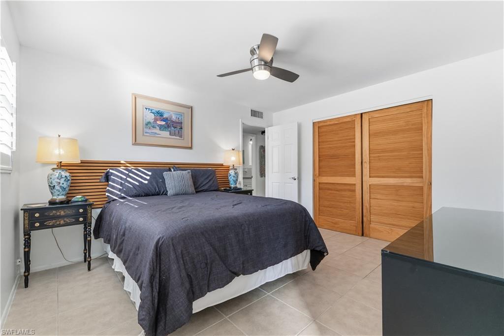 604 110th Avenue North Naples, FL 34108 - Photo 18 of 41 a spacious bedroom with a bed and a closet