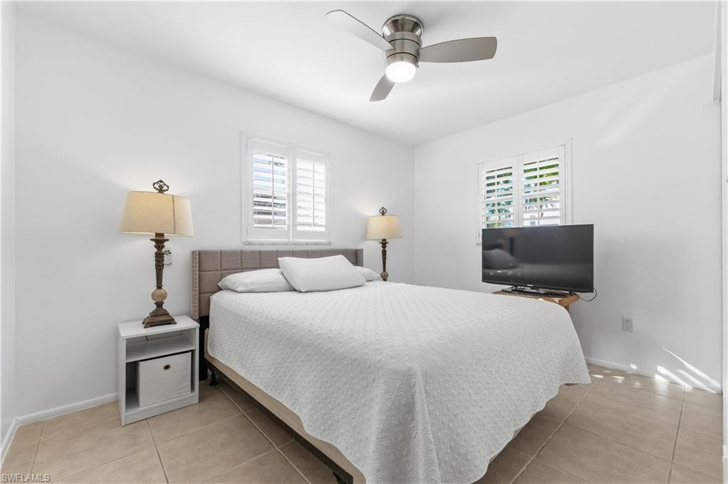 604 110th Avenue North Naples, FL 34108 - Photo 19 of 41 a bedroom with a bed and a flat screen tv
