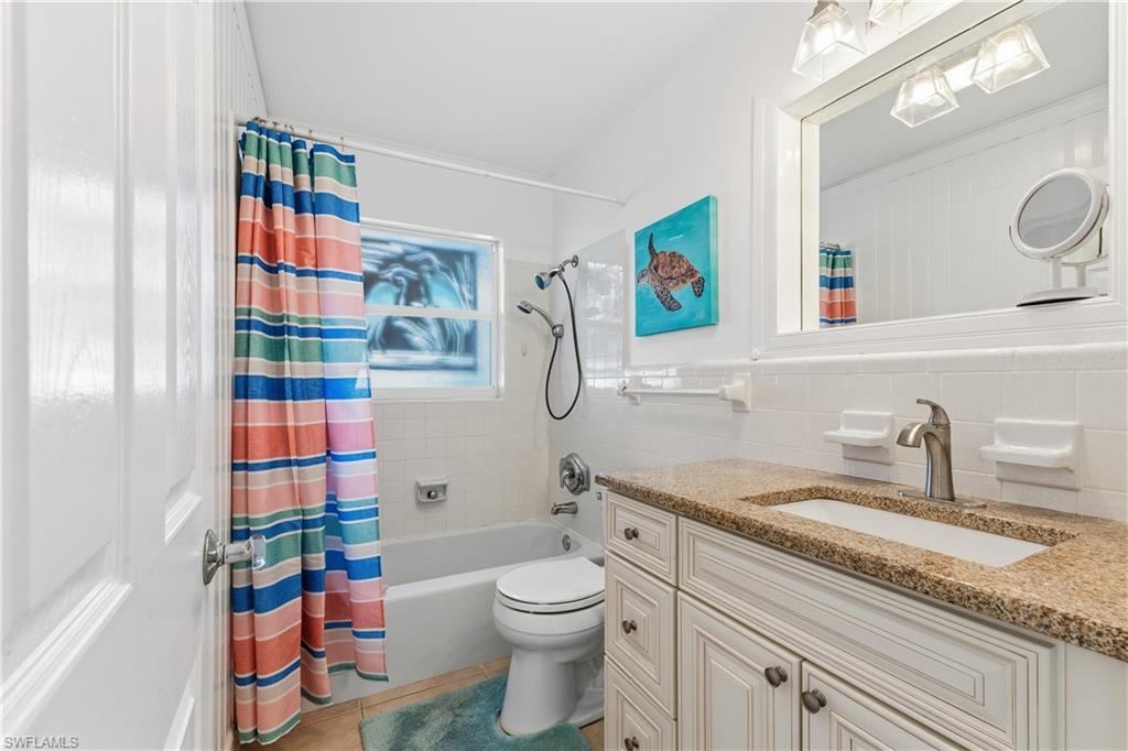 604 110th Avenue North Naples, FL 34108 - Photo 20 of 41 a bathroom with a granite countertop sink mirror vanity and toilet