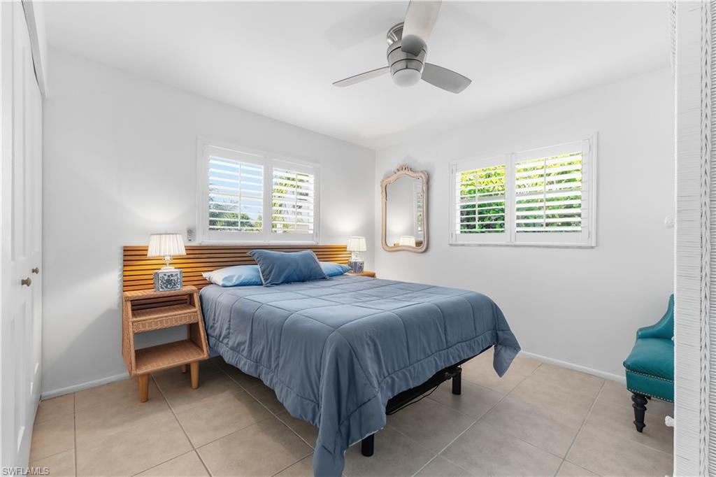 604 110th Avenue North Naples, FL 34108 - Photo 21 of 41 a bedroom with a bed and a table in it
