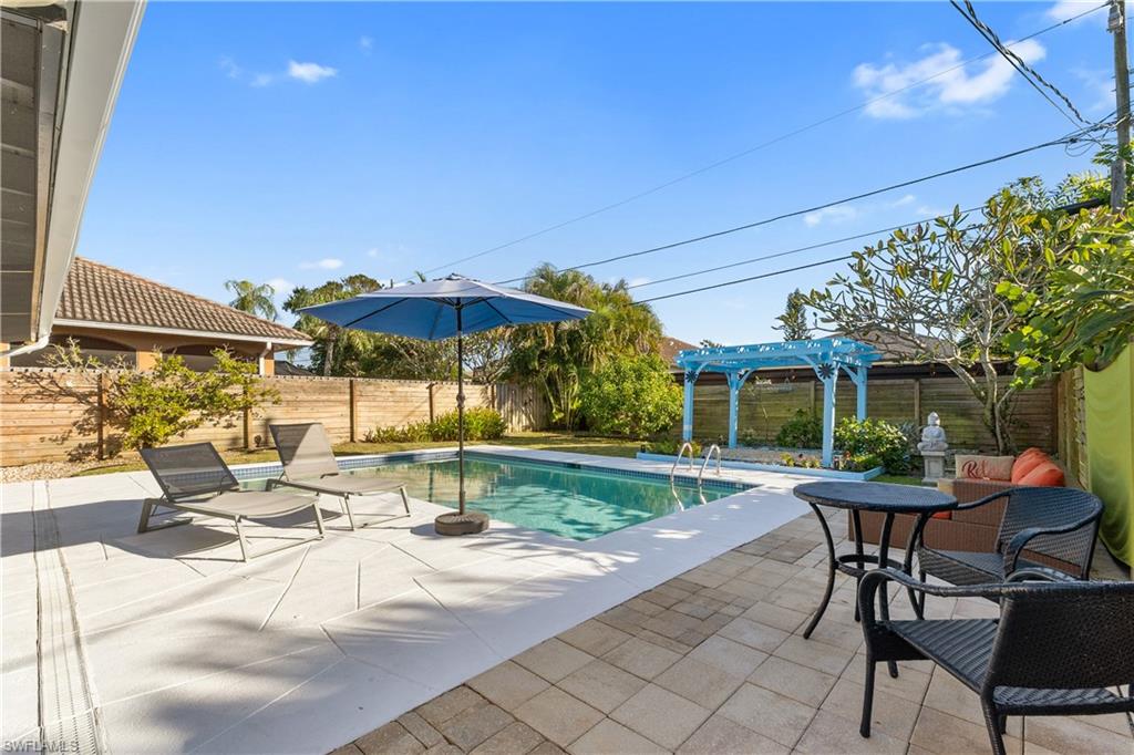 604 110th Avenue North Naples, FL 34108 - Photo 29 of 41 a view of a patio with a table and chairs under an umbrella