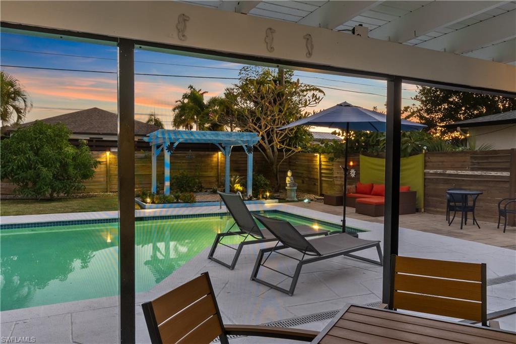 604 110th Avenue North Naples, FL 34108 - Photo 39 of 41 a view of a patio with table and chairs potted plants and floor to ceiling window