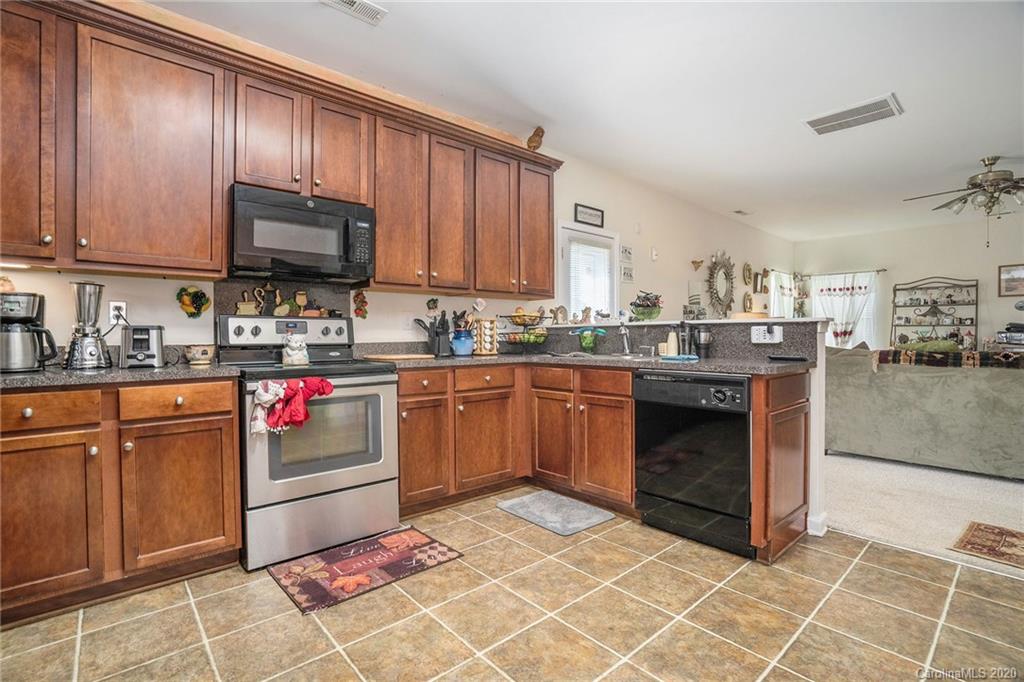 10901 Slalom Hill Road Charlotte, NC 28278 - Photo 14 of 36 a kitchen with stainless steel appliances granite countertop a stove granite counter tops and white cabinets