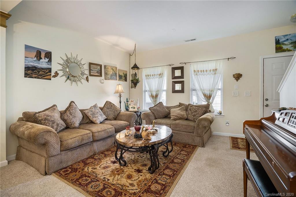 10901 Slalom Hill Road Charlotte, NC 28278 - Photo 5 of 36 a living room with furniture a rug and a wall painting