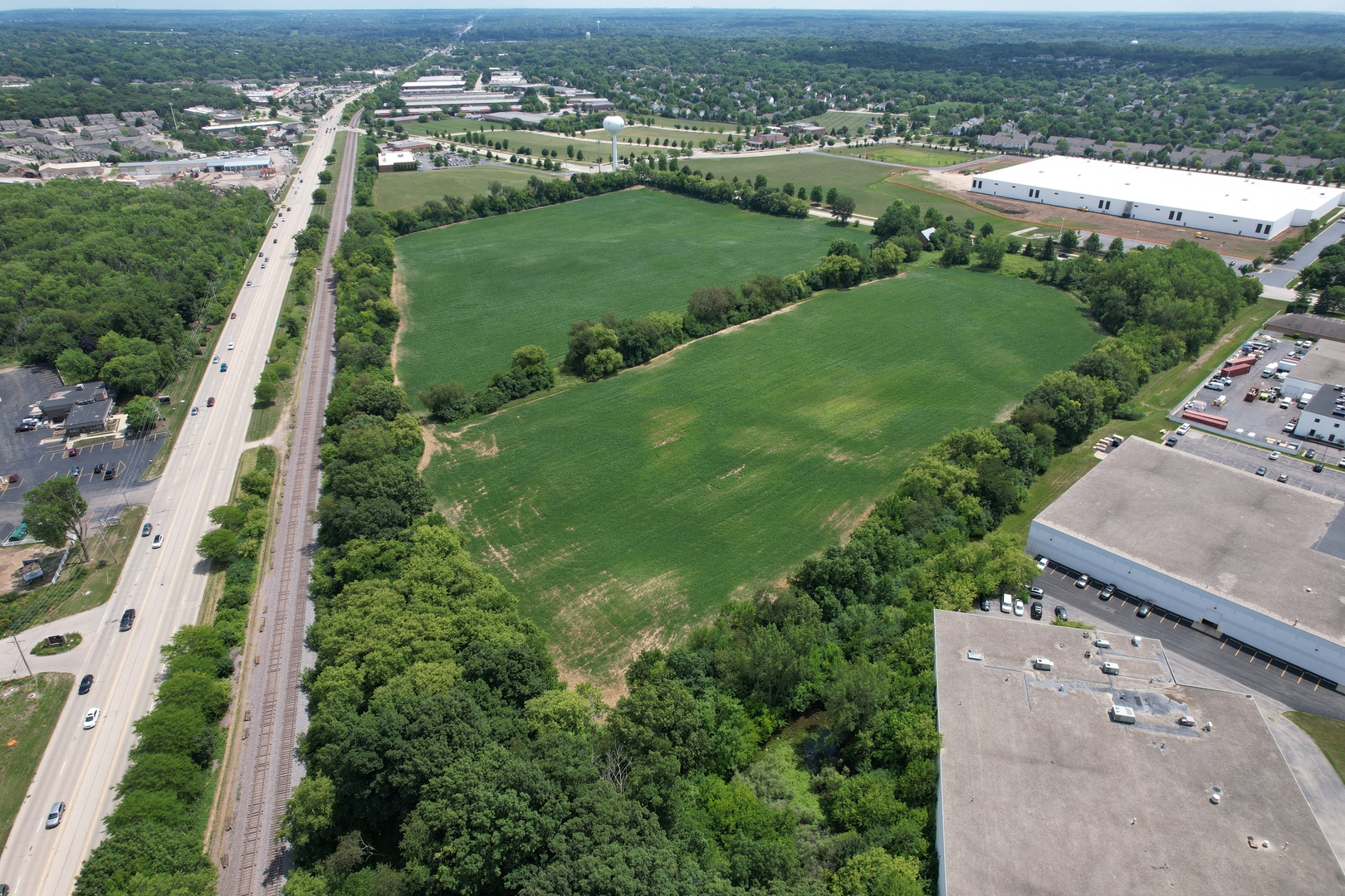 an aerial view of a residential houses with outdoor space and trees