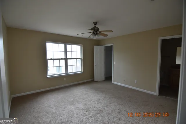 an empty room with a window and a ceiling fan
