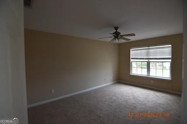 an empty room with a window and a ceiling fan