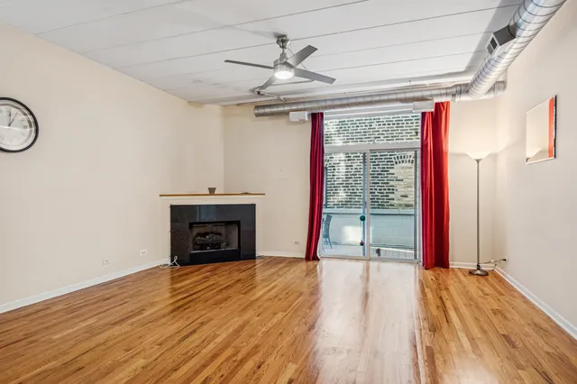 a view of empty room with wooden floor and fireplace