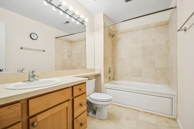 a bathroom with a shower sink vanity mirror and toilet