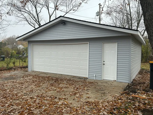 a small white house with a small yard and large tree