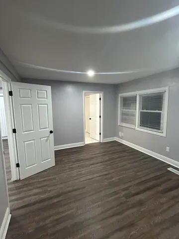 a view of empty room with wooden floor and entryway