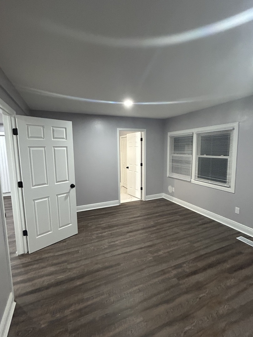 616 Parkside Circle Streamwood, IL 60107 - Photo 9 of 15 a view of empty room with wooden floor and entryway