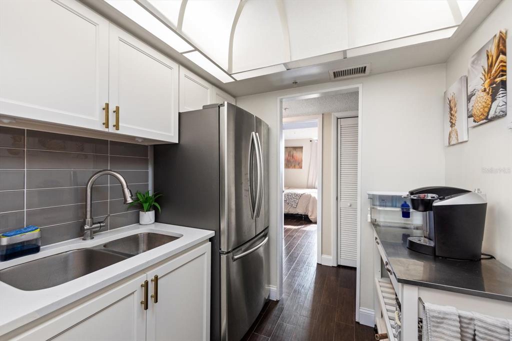 255 Dolphin Point, Unit 508 Clearwater Beach, FL 33767 - Photo 22 of 40 a kitchen with stainless steel appliances a refrigerator a sink a stove and cabinets