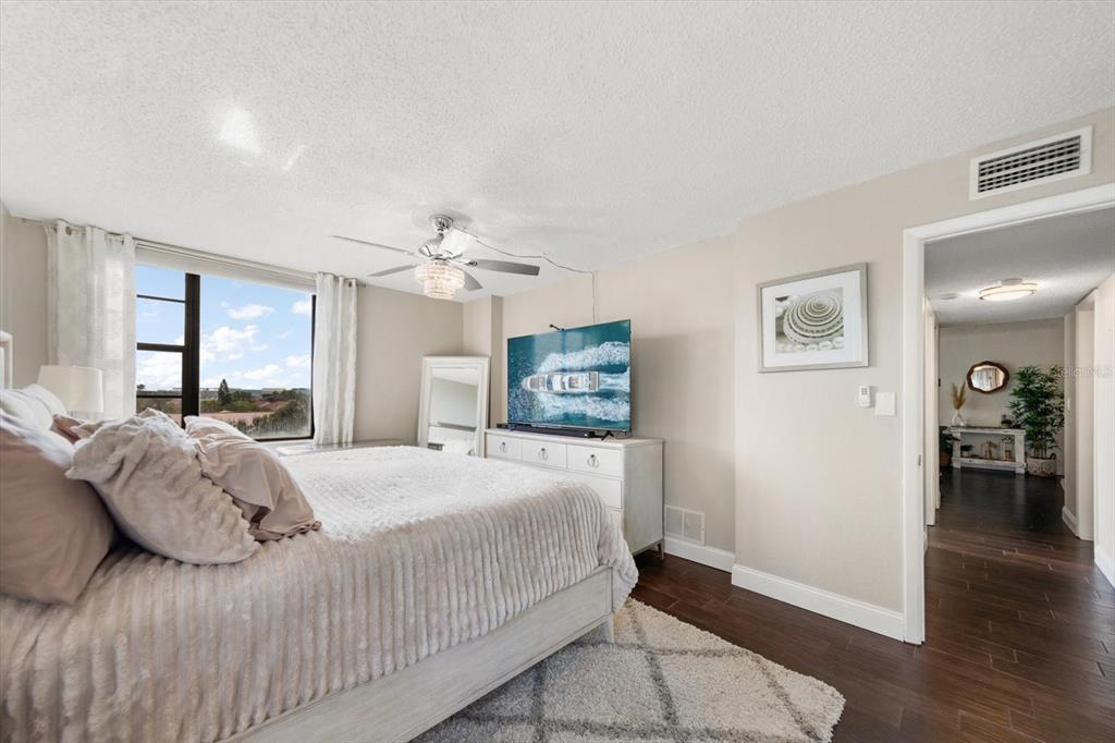 255 Dolphin Point, Unit 508 Clearwater Beach, FL 33767 - Photo 27 of 40 a bedroom with a large bed chandelier and a window
