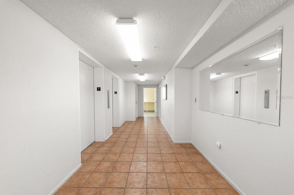 255 Dolphin Point, Unit 508 Clearwater Beach, FL 33767 - Photo 8 of 40 a view of a hallway with white walls