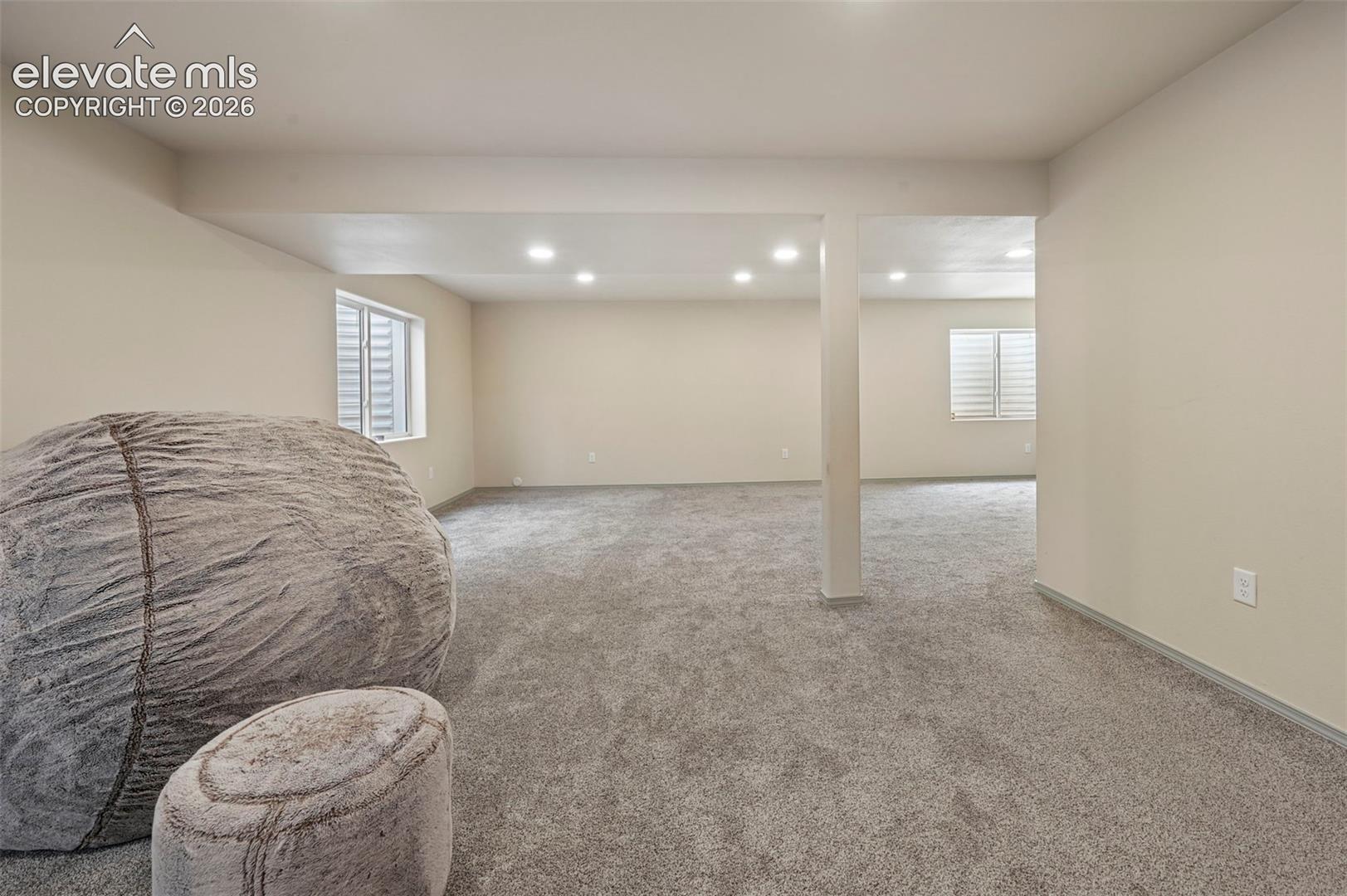 8347 Tibbs Road Peyton, CO 80831 - Photo 8 of 38 Spacious room featuring neutral paint, gray carpeting, recessed lighting, and white window shutters