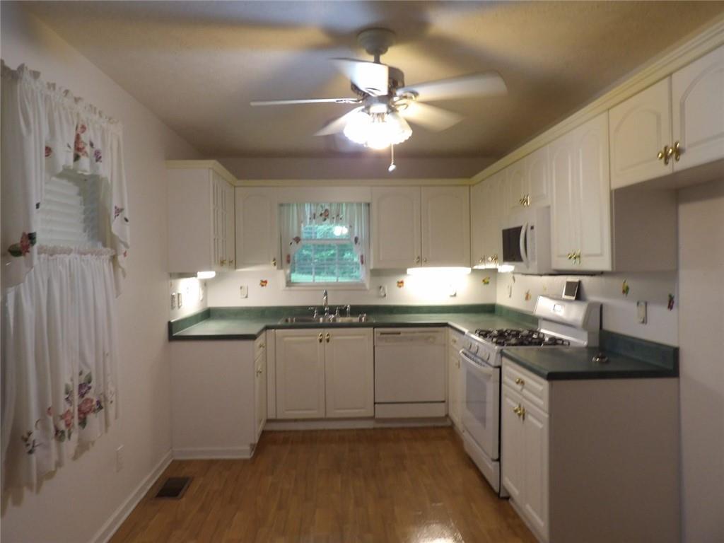 676 Graham Road Dallas, GA 30132 - Photo 5 of 19 a kitchen with granite countertop a sink stainless steel appliances and cabinets