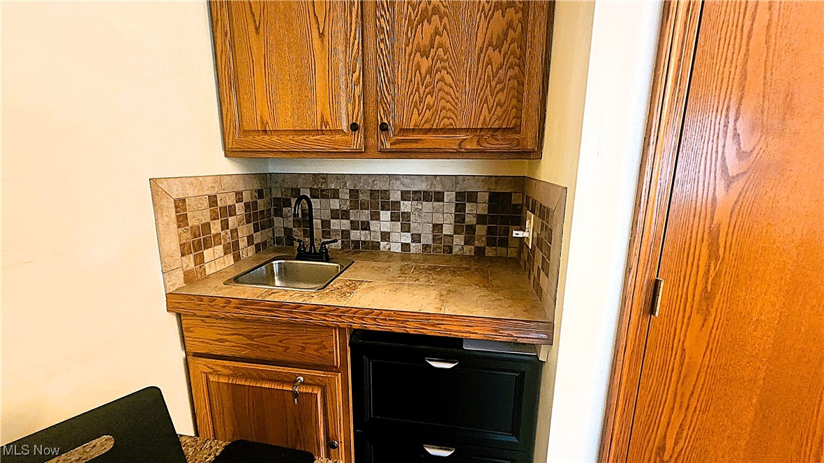 8329 Seasons Road Streetsboro, OH 44241 - Photo 27 of 35 Bar featuring tasteful backsplash and sink