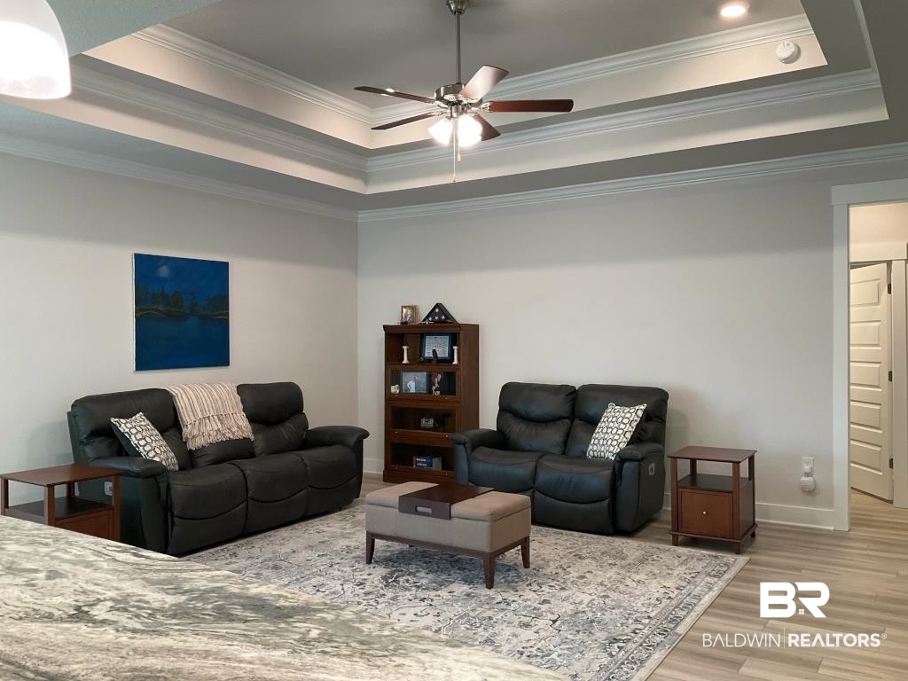 1093 Pheasant Circle Foley, AL 36535 - Photo 5 of 25 Living room featuring a raised ceiling, crown molding, wood finished floors, and a ceiling fan