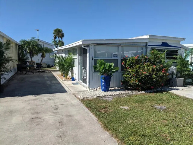 a view of a house with potted plants and a yard