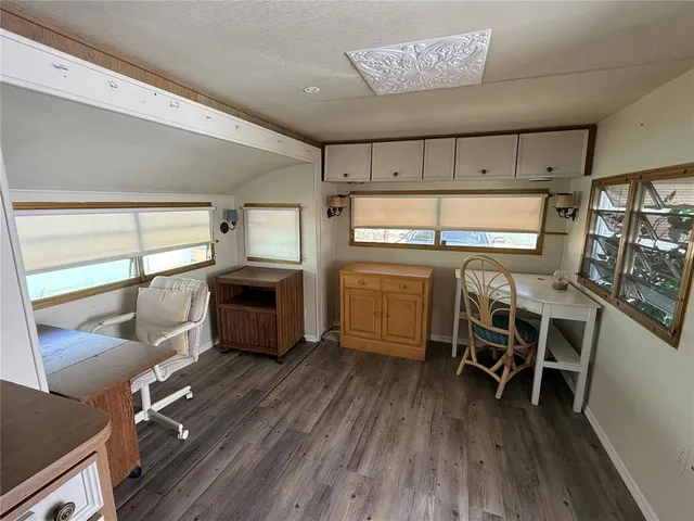 a kitchen with a table chairs refrigerator and cabinets