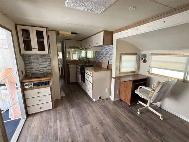 a view of a workspace with furniture and wooden floor