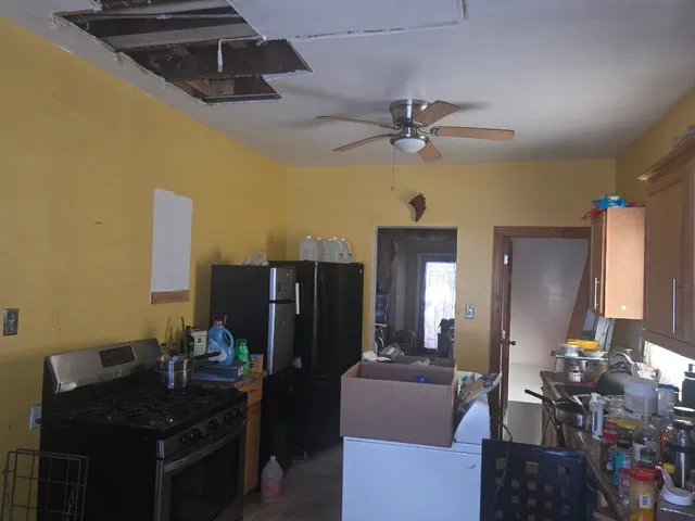 a dining room with furniture and a chandelier fan