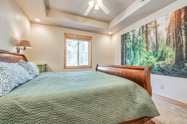 a spacious bathroom with a granite countertop double vanity sink a mirror and a bathtub
