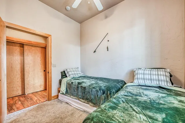 a bedroom with a bed dresser and flat screen tv